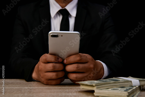 Finance Business Concepts. Lots of money on a black background. Investments are a necessity of business. Businessman looking at a lot of money.