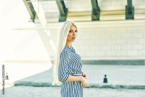 Attractive young blonde girl in town. Beautiful fashionable woman in summer outdoors . Women's beauty and fashion concept