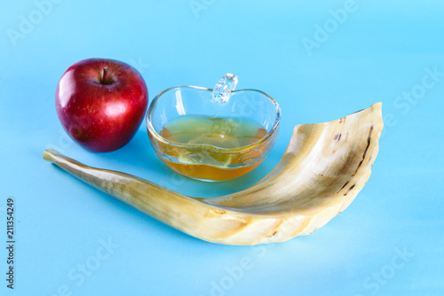 Rosh Ha Shana - Jewish new year composition of an red apple,  jar of honey and Shofar horn for Rosh Hashanah.