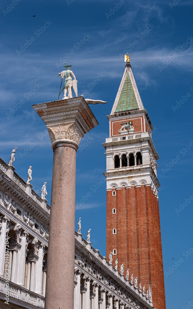 The column of St. Theodore and the bell tower of St. Mark-Campanile-in the center of Venice. In the background, the clock tower