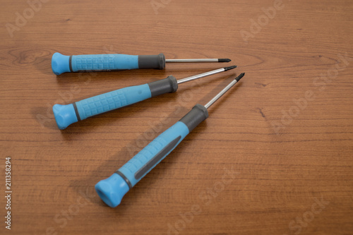 Tools, blue screwdriver on a walnut table