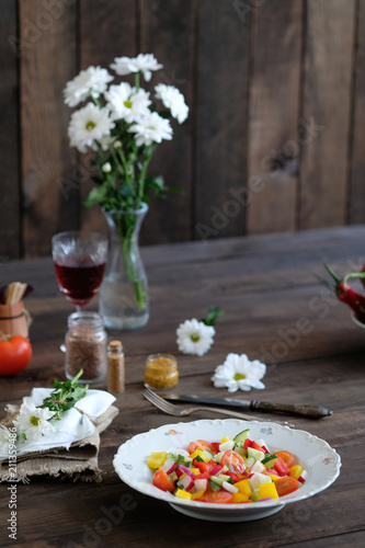 wine, flowers and salad from vegetables on old wooden table