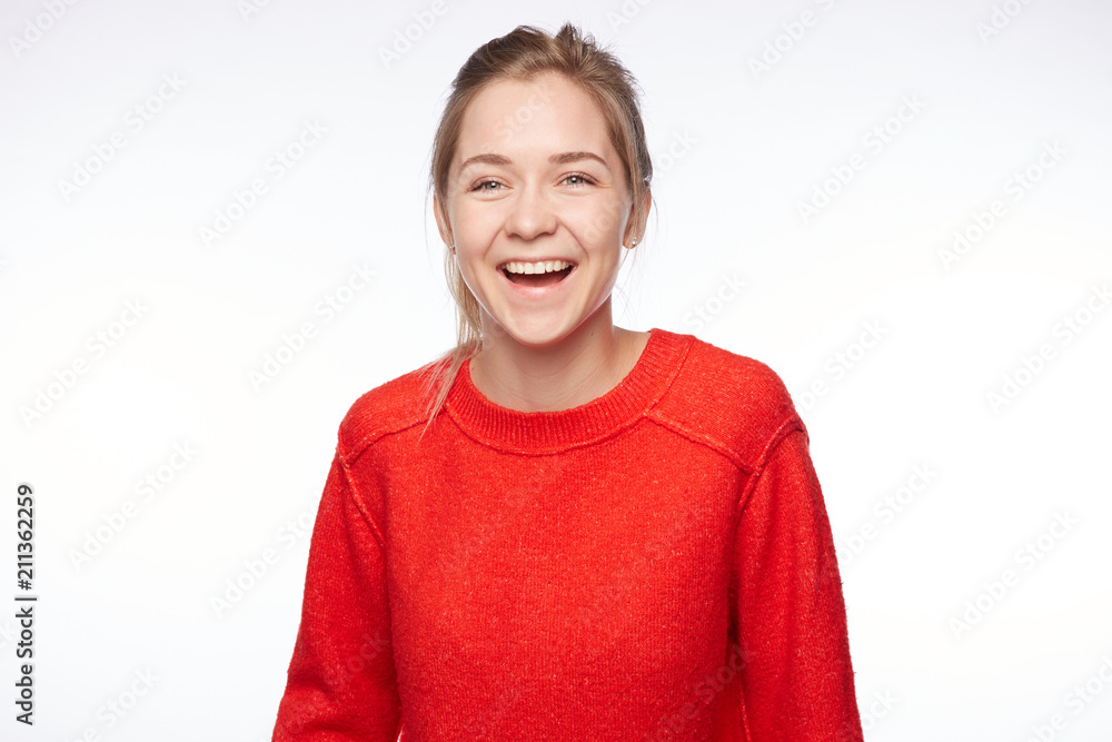 Excited blond female wears red casual clothes watches soccer match with friends, being great football fan, involved in game, screams happily because of scored goal, rejoice team`s victory and success. Excited blond female wears red casual clothes watches soccer match with friends, being great football fan, involved in game, screams happily because of scored goal, rejoice team`s victory and success.