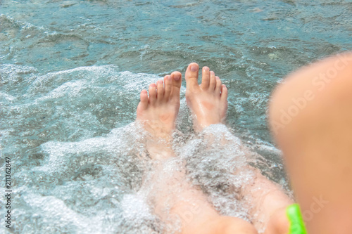 Girl's legs in the sea water in summer