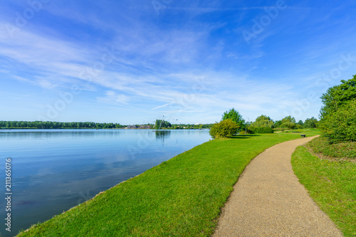 Willen Lake with pedestrian path at sunny summer day 