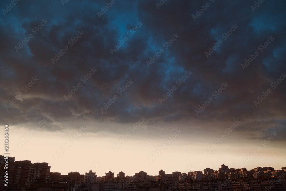 Modern city skyline. Dramatic stormy clouds over modern residential buildings.