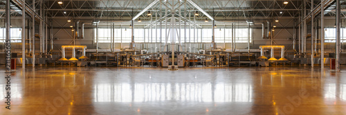 Blurred and defocused background as if empty typical industrial interior. Concept of manufacture, warehouse, storage, factory space.Wide panoramic image. Horizontal banner. Copy space.