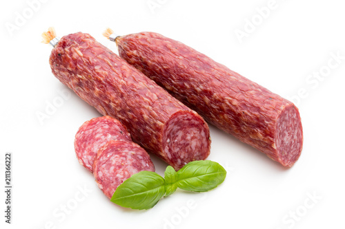 Salami smoked sausage, basil leaves and peppercorns isolated on white background.