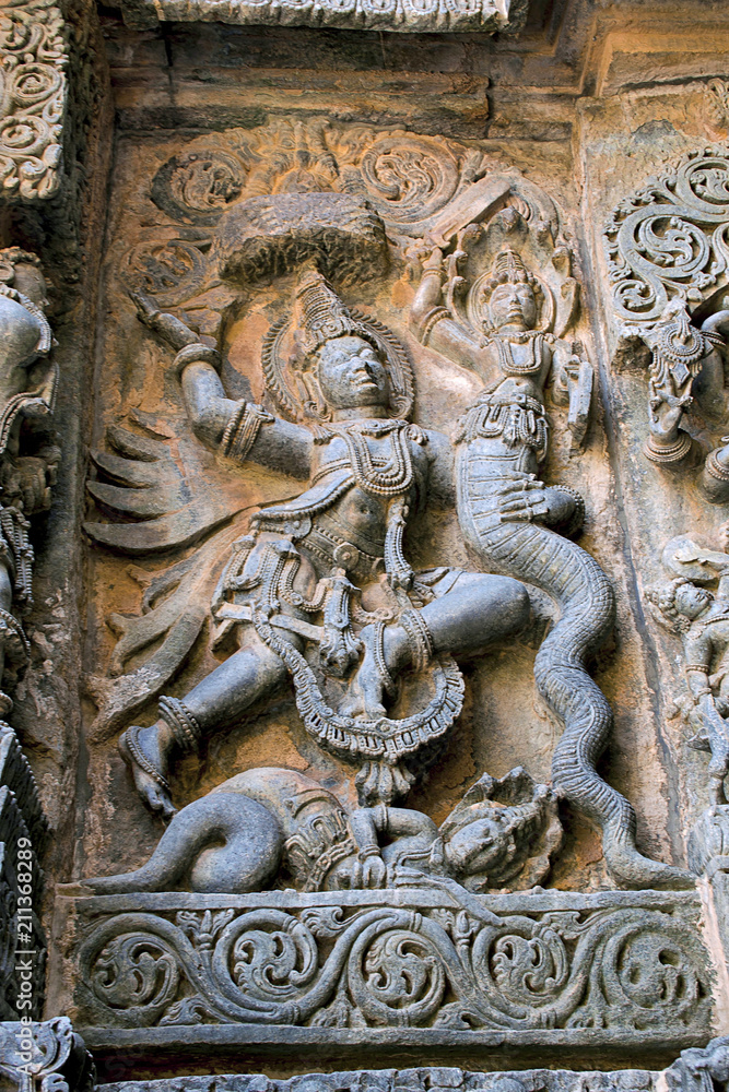 Sculpture depicting Garuda vehicle of lord Vishnu fighting with the snakes in the centre, west side, Hoysaleshwara temple, Halebidu, Karnataka Sculpture depicting Garuda vehicle of lord Vishnu fighting with the snakes in the centre, west side, Hoysaleshwara temple, Halebidu, Karnataka