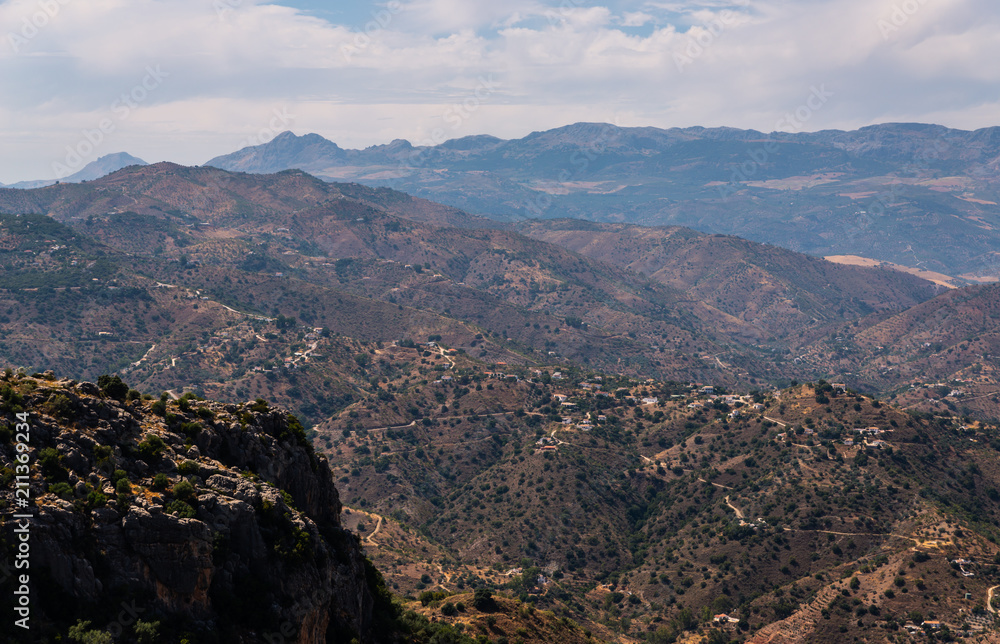 beautiful view of the mountains in the region of Andalusia, houses and farmland on the slopes of mountains