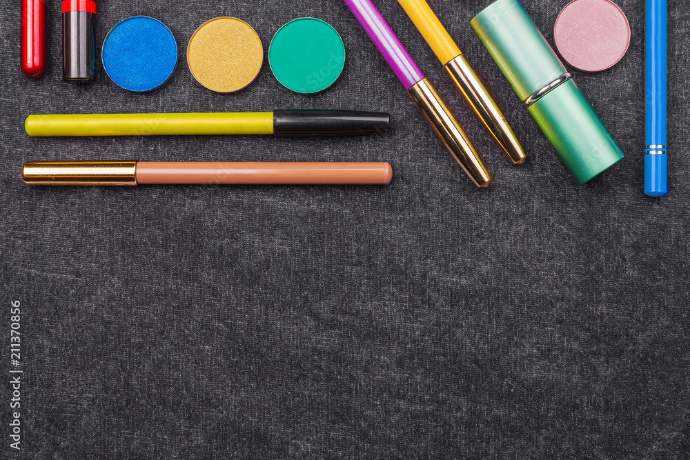 Naklejka premium tools of professional make up artist. lipstick eye pencil mascara and eye shadows. concept of healthy cosmetics. black background and free space for text