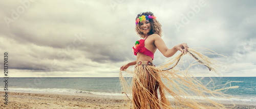 Happy and cheerful hawaiian woman portrait dancing on the beach, letterbox