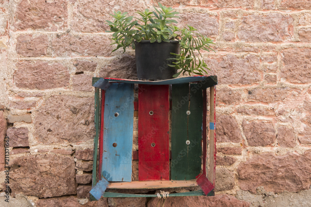 A painted chest and a succulent pot on vinatge wall in Cunda, Ayvalik, Turkey A painted chest and a succulent pot on vinatge wall in Cunda, Ayvalik, Turkey