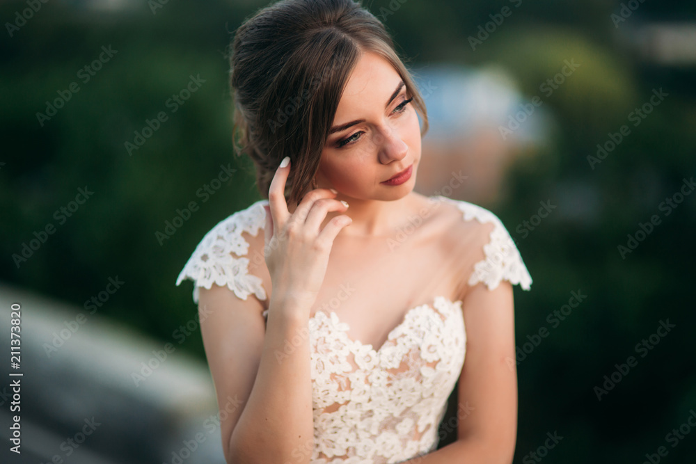 Teenage girl in wedding dress on city. Background town sunset Teenage girl in wedding dress on city. Background town sunset