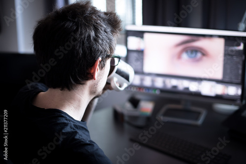 Junger Mann arbeitet an PC, Home-Office, Aufnahme von hinten