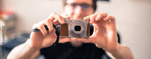 Junger Mann hält Retro-Digitalkamera in der Hand, Breitbild 