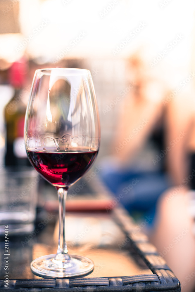 Weinglas mit Rotwein, Gartenparty, Gastgarten in der Abendsonne 