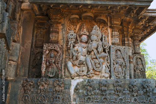 Sculptures on the facade, west side walls. Shiva-Parvati. Hoysaleshwara temple, Halebidu, Karnataka, India.