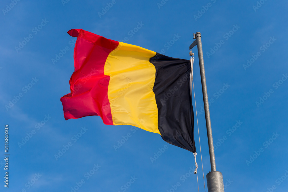 Belgian flag waving against blue sky in Boulogne sur Mer, France. Belgian flag waving against blue sky in Boulogne sur Mer, France.