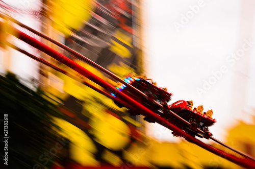 Enjoying a roller coaster ride in family holiday theme park in florida under clear blue sky in summer vacation