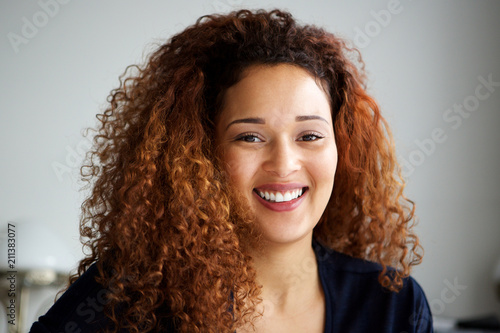 Close up attractive young woman with curly hair smiling