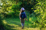 Traveler young girl with backpack walking on path in the tropical forest