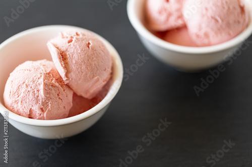 Strawberry Ice Cream balls  In Bowl with mint over black background.