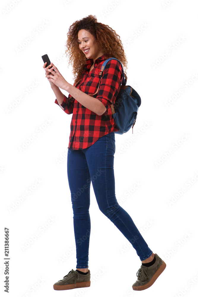 Full body young woman walking on isolated white background with mobile phone and bag Full body young woman walking on isolated white background with mobile phone and bag