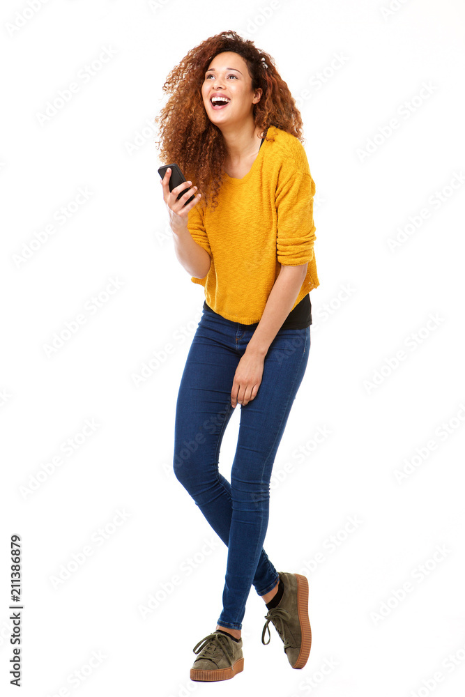 Full body happy woman with smart phone laughing against isolated white background Full body happy woman with smart phone laughing against isolated white background
