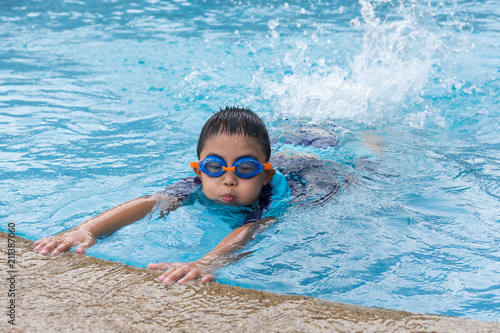 young boy swimming in pool.