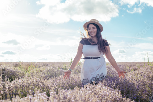 young pretty plus size female having fun in lavender field during sunset