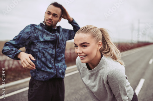 Smiling young couple preparing for an outdoor run together