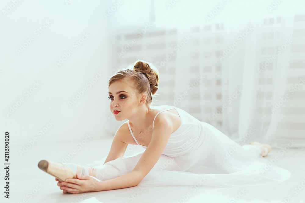 Beautiful ballerina is posing and dancing in a white studio full of light. The photo greatly reflects the incomparable beauty of a classical ballet art. Beautiful ballerina is posing and dancing in a white studio full of light. The photo greatly reflects the incomparable beauty of a classical ballet art.