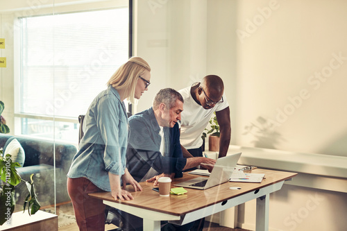 Diverse businesspeople working together on a laptop at a desk