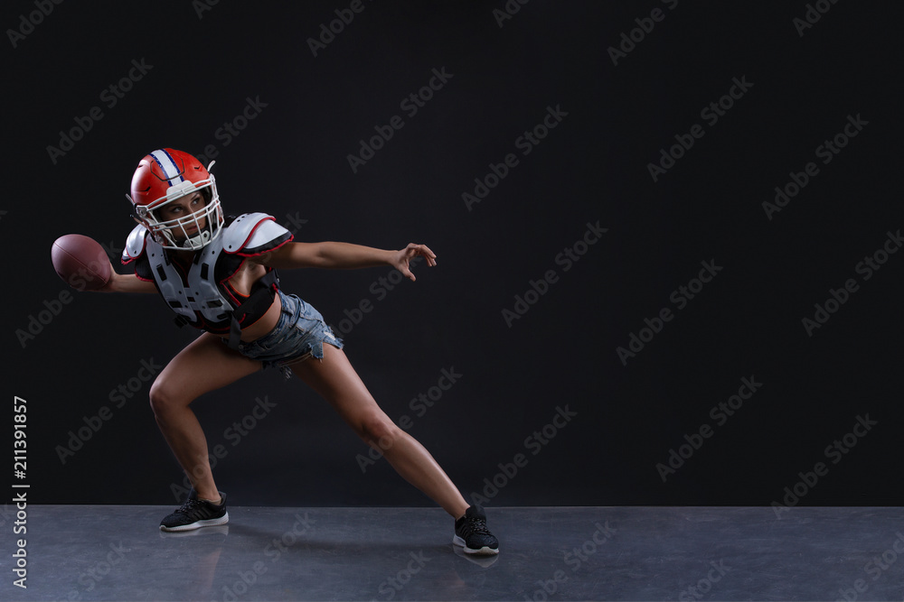 Sexual sportive woman running with rugby ball and screaming aggressively at black background. gender equality