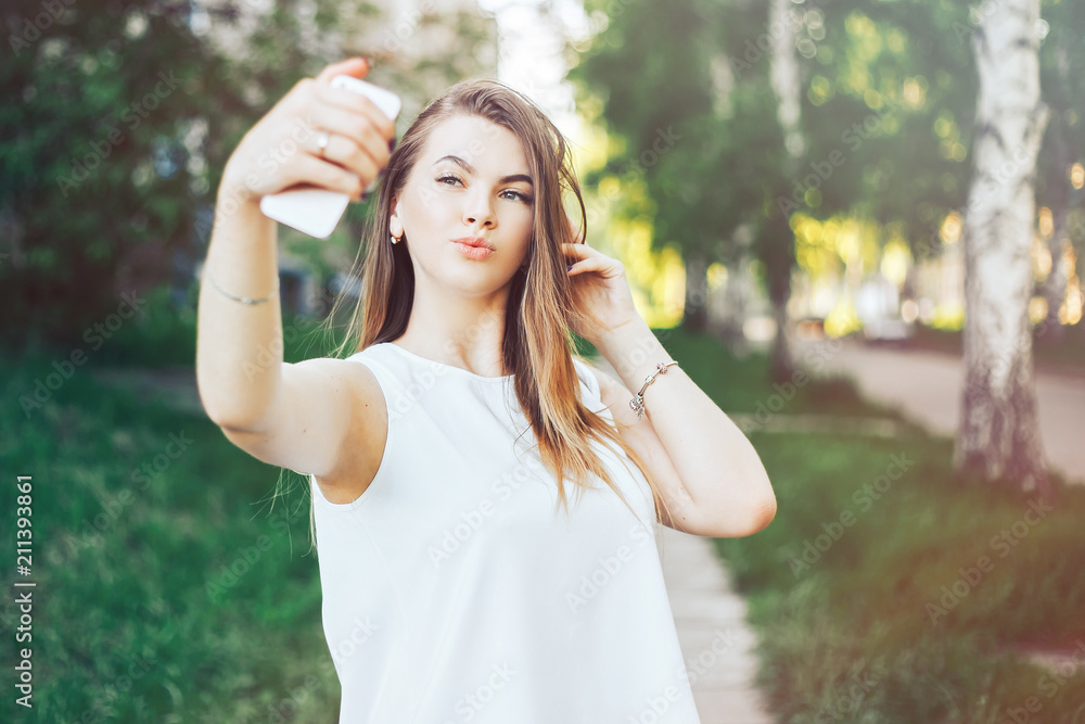 young beautiful woman, teenager, making selfie in park