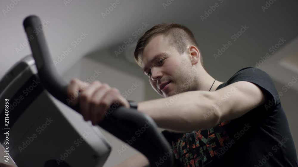 guy glad to start pedals on the new exercise bike and track the time in the new gym guy glad to start pedals on the new exercise bike and track the time in the new gym