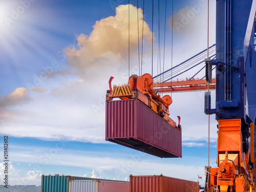 Containers are discharging from vessel by port crane at port of Thailand, Closeup crane to pick up container onboard. photo