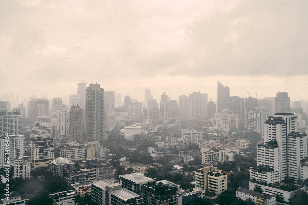 Rain over Bangkok: Cityscape behind the window glass with rain drops.