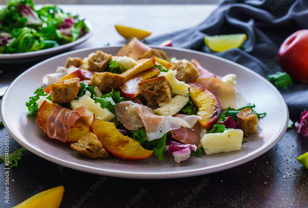 fresh salad of lettuce leaves, pieces of jamon, pieces of crackers and pieces of caramelized peaches and pieces of cheese on the table fresh salad of lettuce leaves, pieces of jamon, pieces of crackers and pieces of caramelized peaches and pieces of cheese on the table