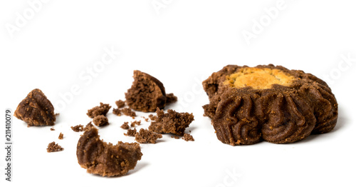 Broken dark cookies and crumbs on a white, isolated.