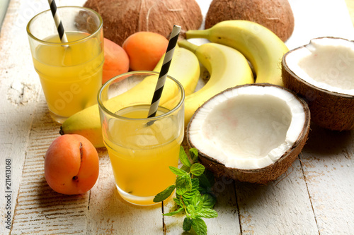 Fototapeta Naklejka Na Ścianę i Meble -  tropical fruits drink with around coconut, bananas and apricots