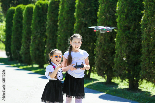 children play with selfish drones. Two girls are launching a quadrocopter