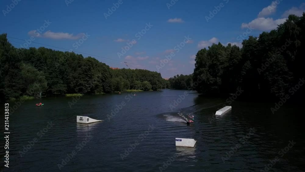 Aerial shot of a cableway in a lake with a wakeboarder grinding and rotating on a funbox Aerial shot of a cableway in a lake with a wakeboarder grinding and rotating on a funbox