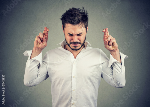 man keeping fingers crossed making a wish