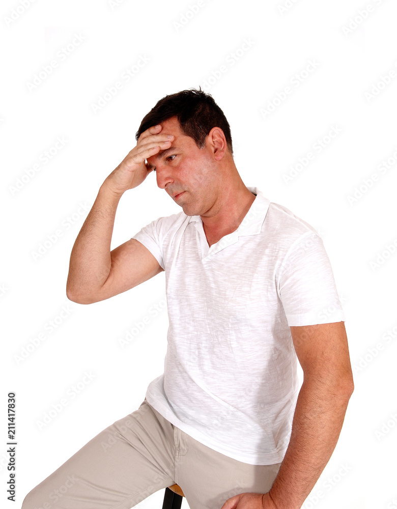 Middle age man covering is face for worries Middle age man covering is face for worries