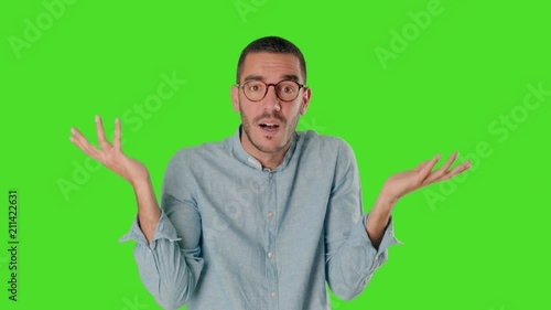 Puzzled young man on chroma screen with a gesture of confusion