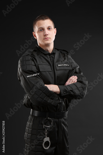 Male security guard in uniform on dark background © New Africa