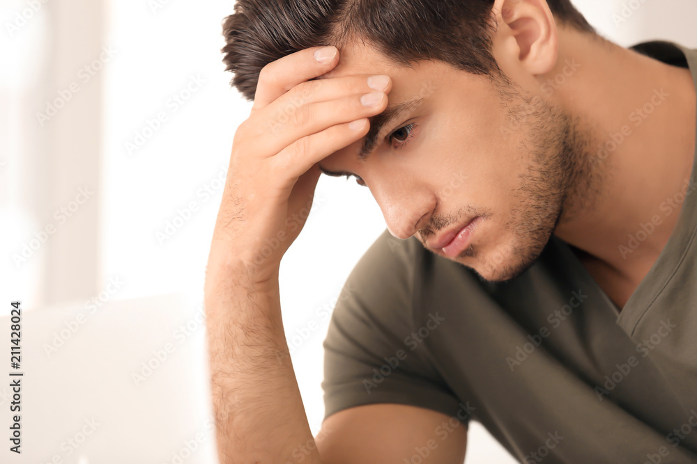 Fototapeta premium Portrait of serious young man on light background