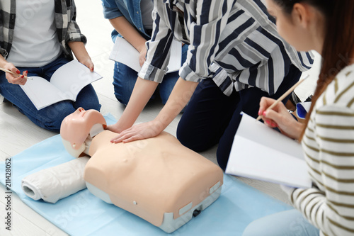 Obraz na plátně Group of people practicing CPR on mannequin at first aid class